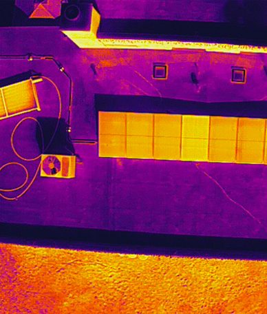 Aerial view of a large commercial rooftop solar array during drone inspection