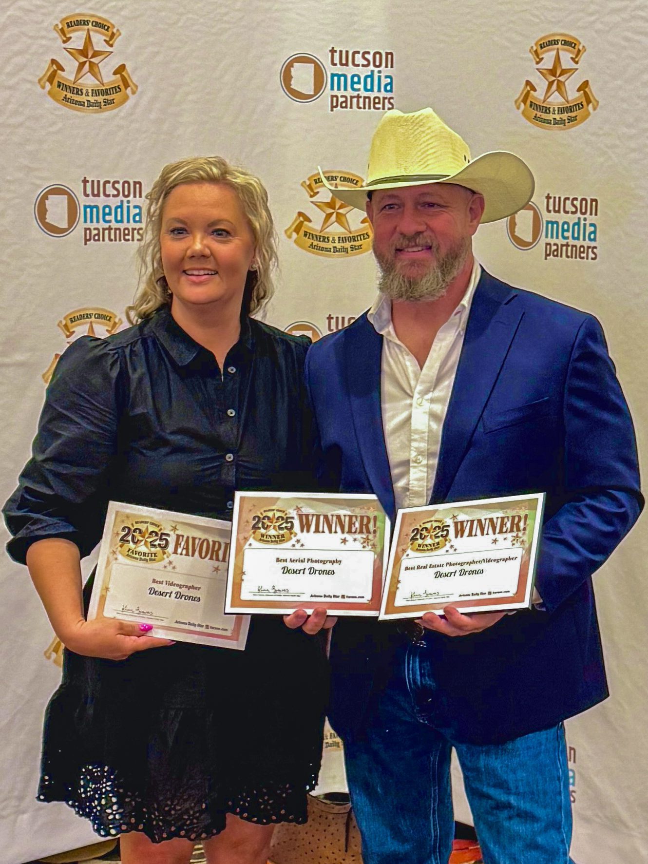 John and Destiny Ott, founders of Desert Drones LLC, holding their 2025 Daily Star Readers Choice Award certificates for Best Aerial Photography and Best Real Estate Photographer