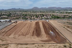 Aerial of graded earthwork and stockpiles on a construction site