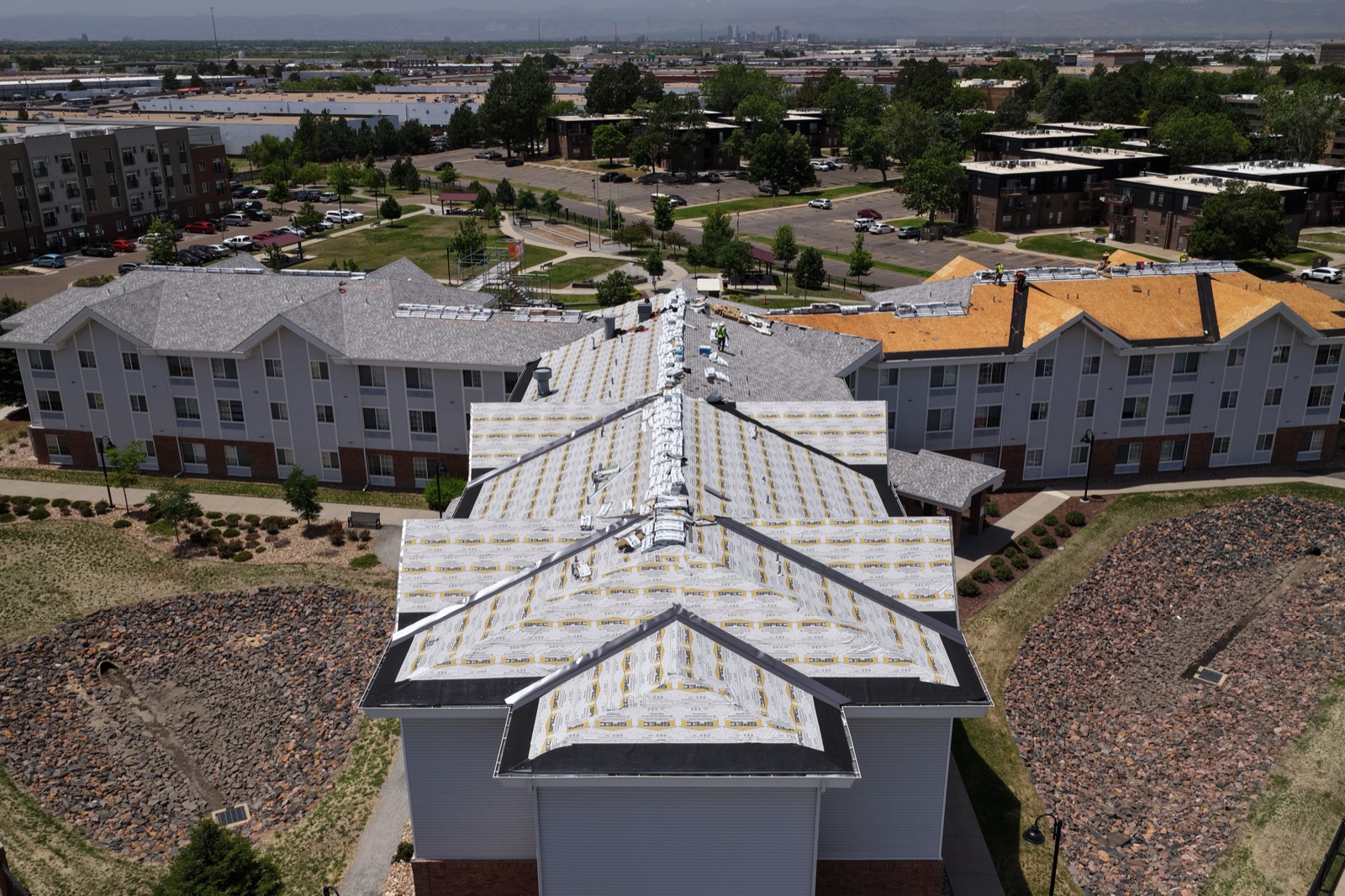 Low aerial sweep along a multifamily roofline in northeast Denver