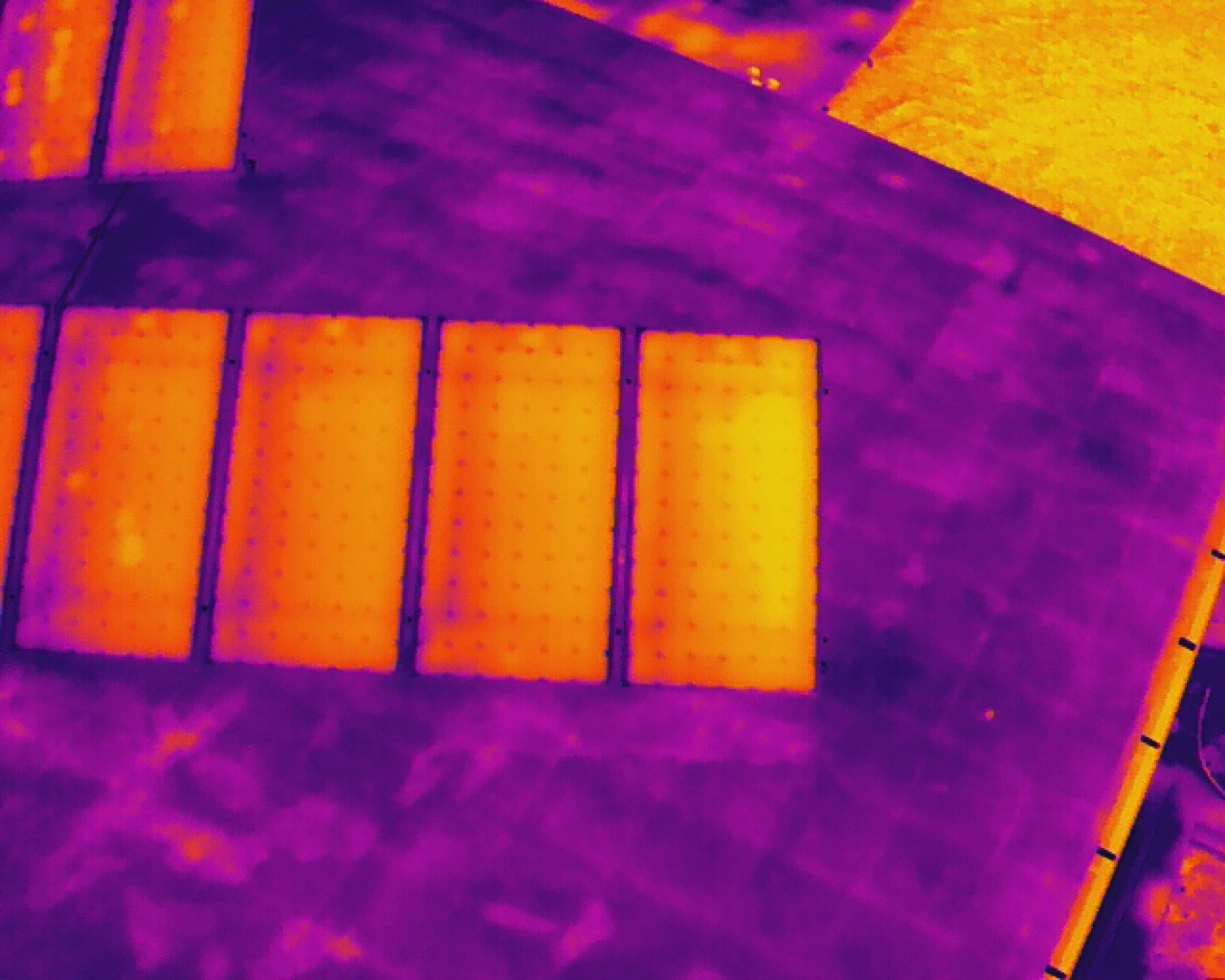 Radiometric thermal drone image showing heat anomalies on a commercial roof