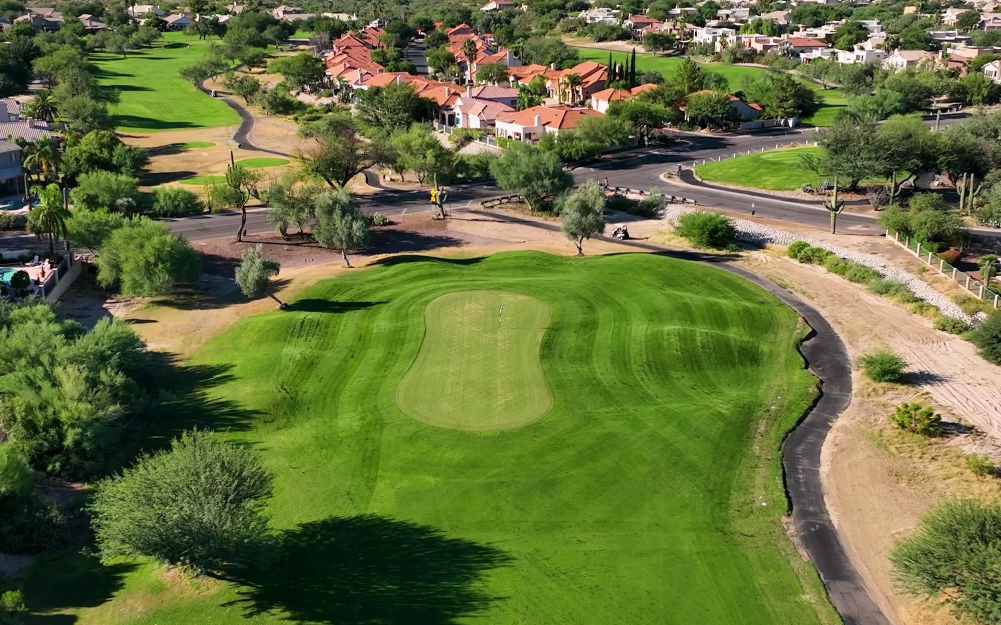 Aerial drone photo of a lush golf course community at golden hour