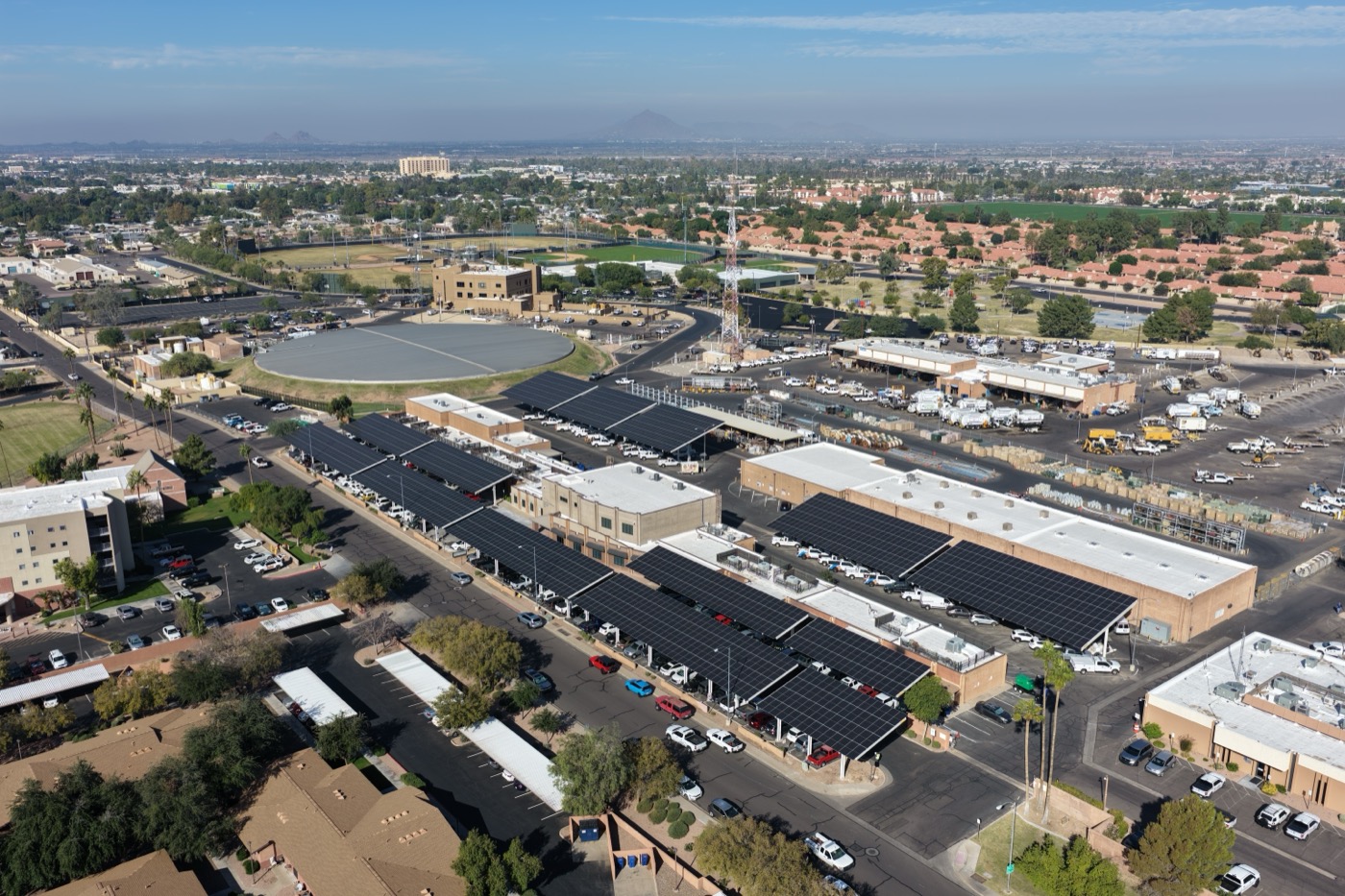 Aerial of solar carport rows with Phoenix valley backdrop, Mesa AZ