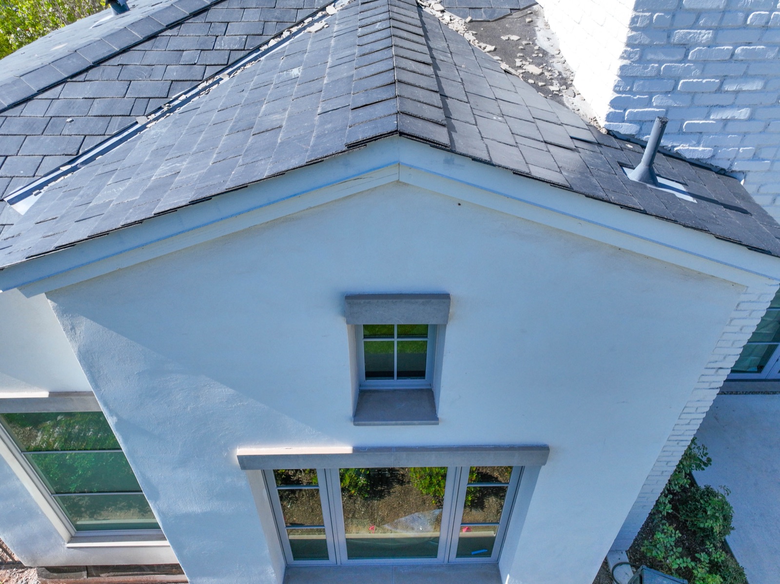 Low-altitude drone detail of a roof drainage canale and penetration on a flat roof