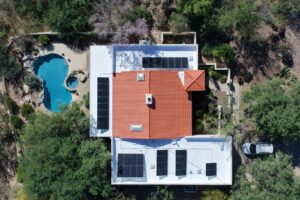 Aerial of an Albuquerque-area home with a full rooftop solar array and pool