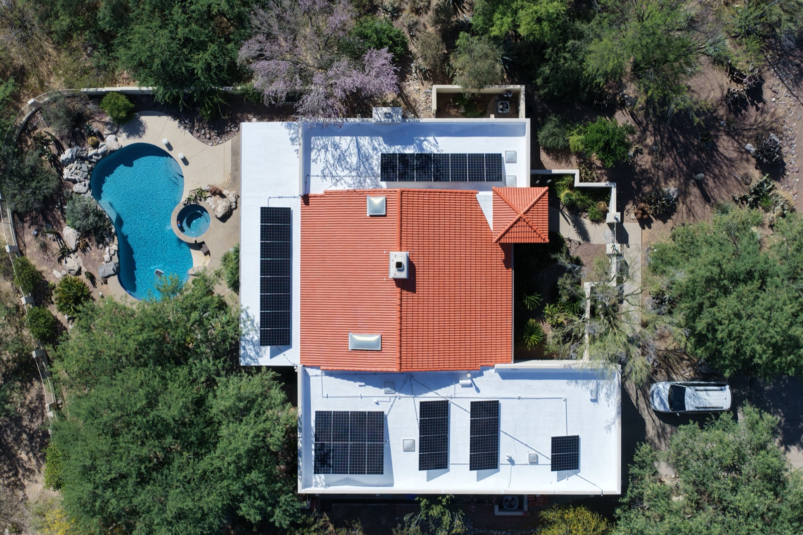 Aerial of an Albuquerque-area home with a full rooftop solar array and pool