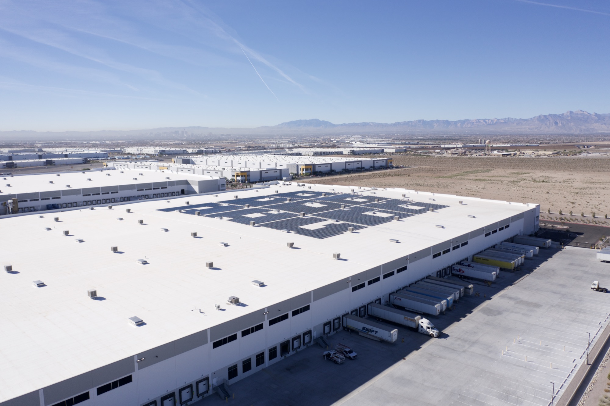 Drone photo of a rooftop solar array on a North Las Vegas distribution center with the Las Vegas skyline behind