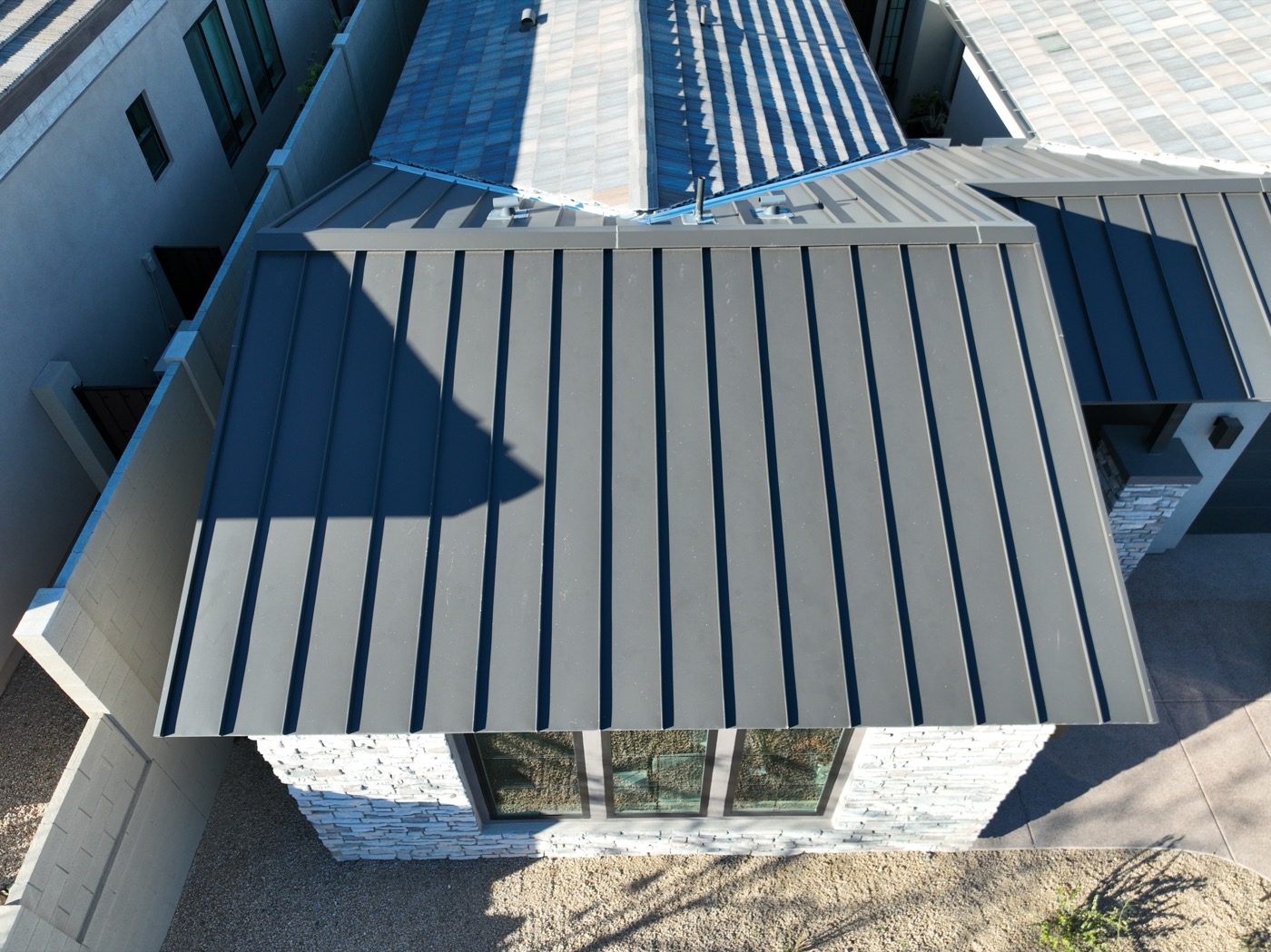 Aerial inspection of a modern standing-seam metal roof on a Scottsdale home