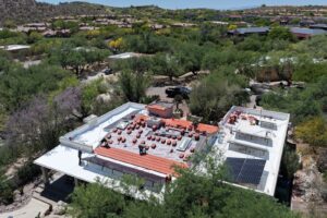 Drone photo of crews installing a rooftop solar array during a re-roof